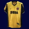 front view of yellow away retro football jersey (2000) with clean collar and retro stripes.