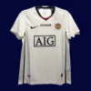 front view of Manchester United away UCL retro jersey (08/09) in blue with UEFA badges.