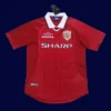 front view of Manchester United home red retro jersey (1999) with traditional collar.