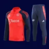front view of red Manchester United tracksuit (2025) with zip-up jacket and tapered fit.