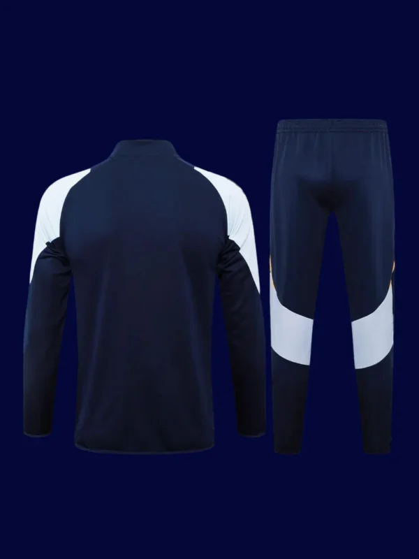 back view of black tracksuit top showing ventilation channels and tapered hem (24/25).