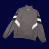 back view of grey windbreaker kit showing ventilation panels and tapered hem (24/25).